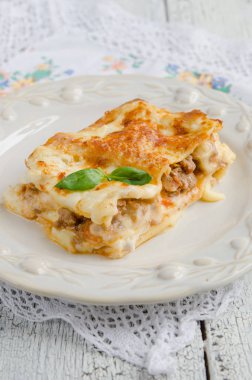Lazanya bolognese ahşap masa üzerinde beyaz plaka