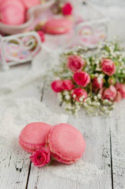 Vanilya macarons ahşap arka plan üzerinde pembe güllü