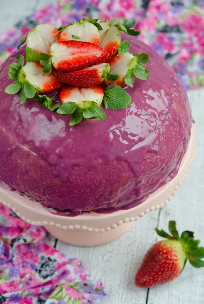 Strawberry mousse cake with purple chocolate glaze, selective focus