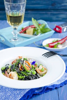 Mürekkep balığı mürekkep ve mavi ahşap masa sebze ile makarna