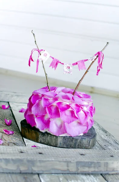Tatlı Kek Ahşap Yüzey Üzerinde Pembe Çiçek Yaprakları Ile Süslenmiş — Stok fotoğraf