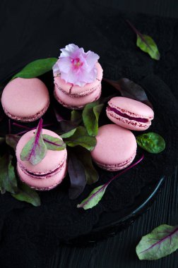 Pembe macarons pancar koyu arka plan üzerinde krem ile