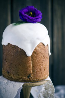 Buzlanma ve çiçeklerle ahşap arka plan üzerinde geleneksel Paskalya kek dekore