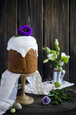 Buzlanma ve çiçeklerle ahşap arka plan üzerinde geleneksel Paskalya kek dekore