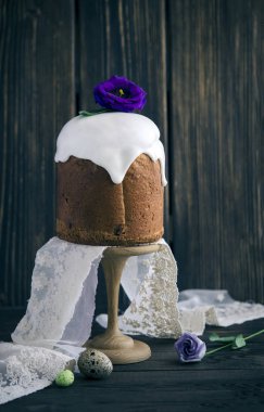 Buzlanma ve çiçeklerle ahşap arka plan üzerinde geleneksel Paskalya kek dekore