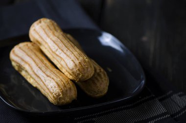 Siyah arka plan üzerine lezzetli vanilyalı eklerleri