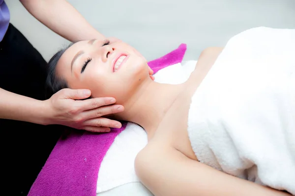 Hermosa mujer está recibiendo un masaje facial en el salón de spa —  Fotos de Stock