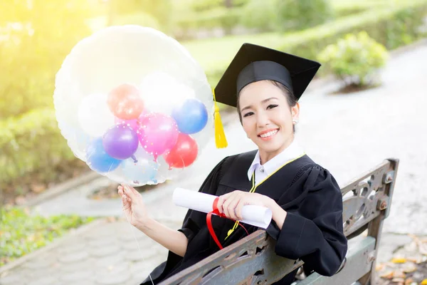 Portrét šťastných mladých absolventů žen v akademických šatech a s — Stock fotografie
