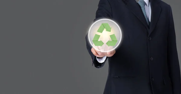 Üzletember mutatott zöld recycle szimbólum szürke háttérb — Stock Fotó