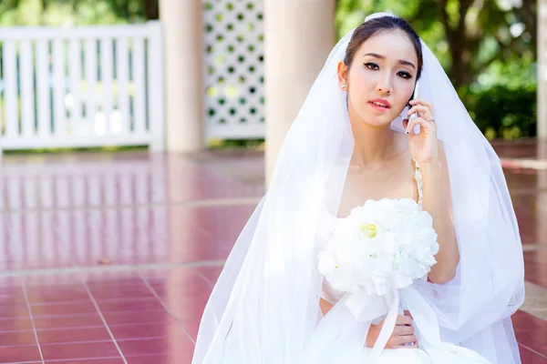 Noiva falando no telefone celular no vestido de noiva — Fotografia de Stock