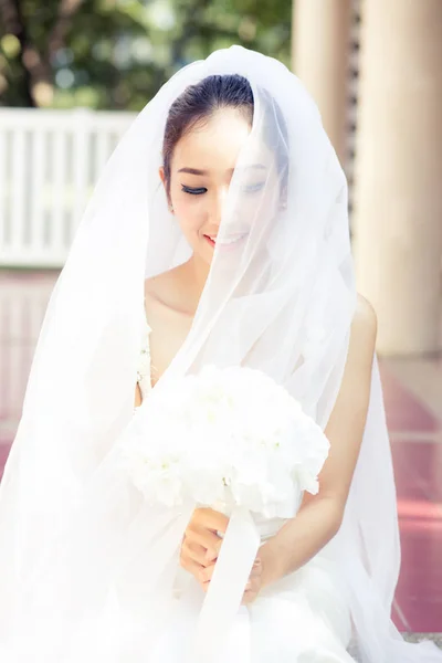 Retrato de uma linda noiva cobrindo seu rosto com um véu. Bri... — Fotografia de Stock