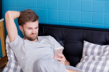 Mutlu adam bir c oturan bir akıllı telefon medya içeriği izlerken