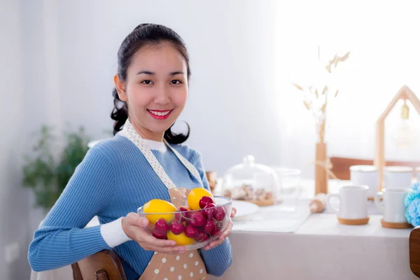 Krásná samice držící misku s úsměvem v kuchyni — Stock fotografie