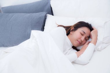 Yatakta yatak odasında evde uyuyan güzel kız.
