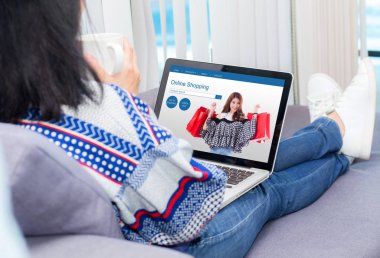 oturma odasında dizüstü bilgisayar ile kanepe alışveriş online genç kadın