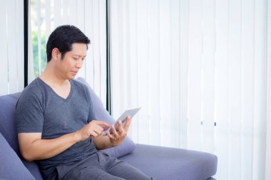 kanepede oturan bir tablet medya içeriği izlerken işadamı
