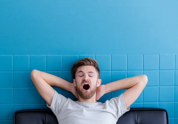 Чоловік позіхає і спить у своїй вітальні — стокове фото