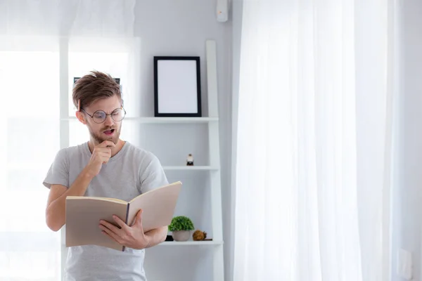 Schöner Kerl mit Brille liest Buch und bereitet Prüfung vor — Stockfoto