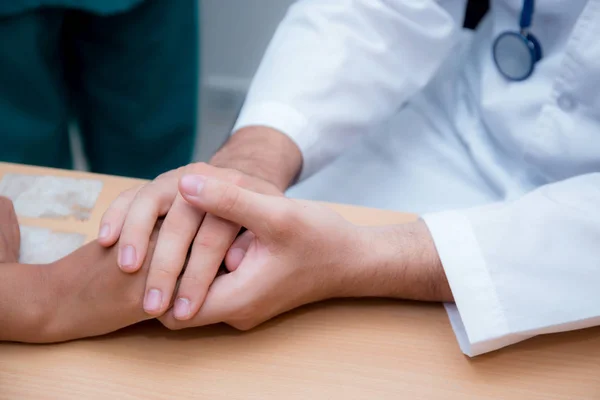 Amigável médico mão segurando paciente mão sentado no de — Fotografia de Stock