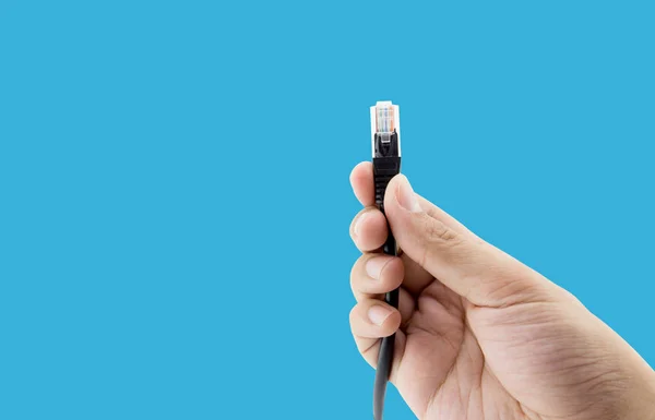 Et LAN-stik i hånden isoleret på blå baggrund - klipning - Stock-foto