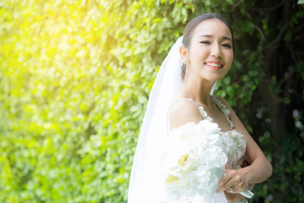 Bela jovem no dia do casamento em vestido branco na árvore — Fotografia de Stock