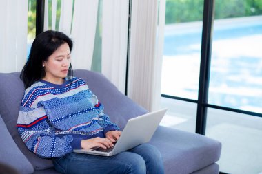 L iş için Asyalı kadın ile kanepede Closeup bilgisayar notebook