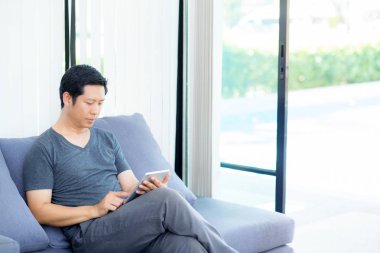 kanepede oturan bir tablet medya içeriği izlerken işadamı
