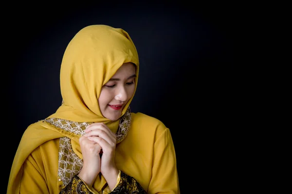 Religious young Muslim woman praying over black background. — Stock Photo, Image