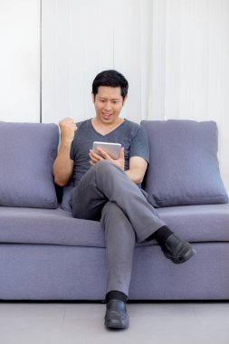 kanepede oturan bir tablet medya içeriği izlerken işadamı