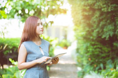 bahçede iş kadını tablet görünümlü - mutlu ve gülümseyen.