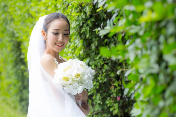 Beautiful young woman on wedding day in white dress in the tree — Stock Photo, Image