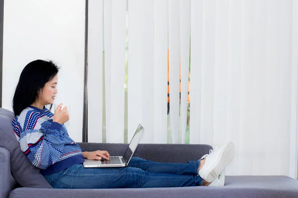 computer notebook on sofa with asian woman for work in lifestyle