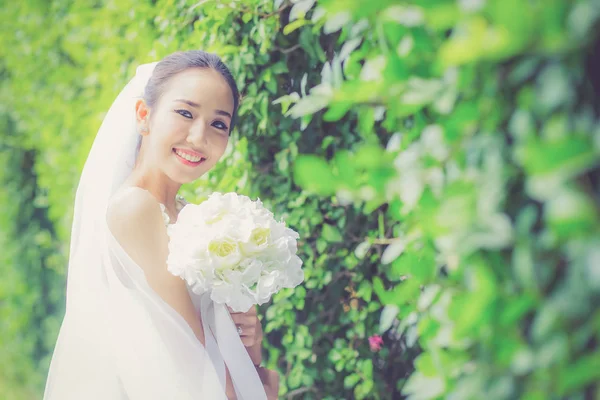 Schöne junge Frau am Hochzeitstag im weißen Kleid im Baum — Stockfoto
