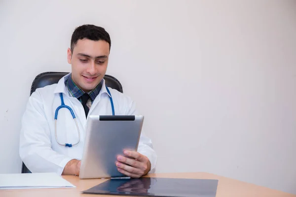 Medico che lavora con l'utilizzo di tablet nel suo ufficio . — Foto Stock