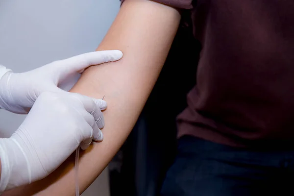 Sjuksköterska sätta en IV nål i en patient hand. — Stockfoto
