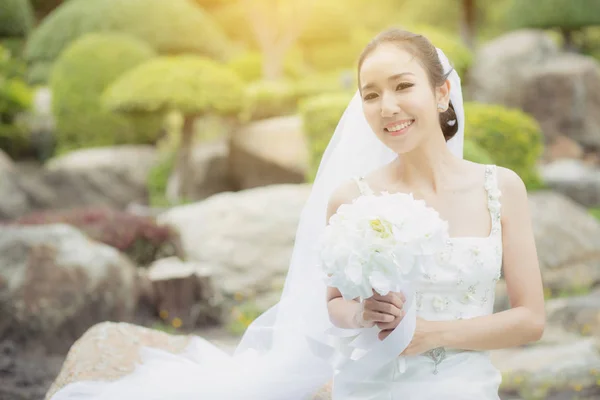 Beautiful young woman on wedding day in white dress in the garde — Stock Photo, Image