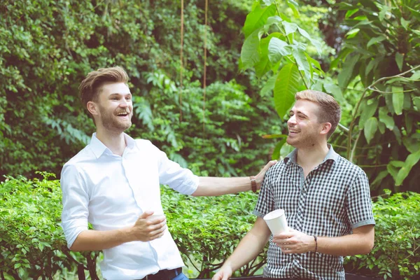 Dos amigos hombres hablando de pie en un jardín . —  Fotos de Stock