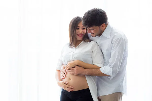 Embarazada madre y padre de pie abrazo celebración vientre, famil —  Fotos de Stock