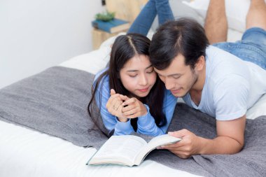 Çift ha ile sabah yatak odasında birlikte bir kitap okuma