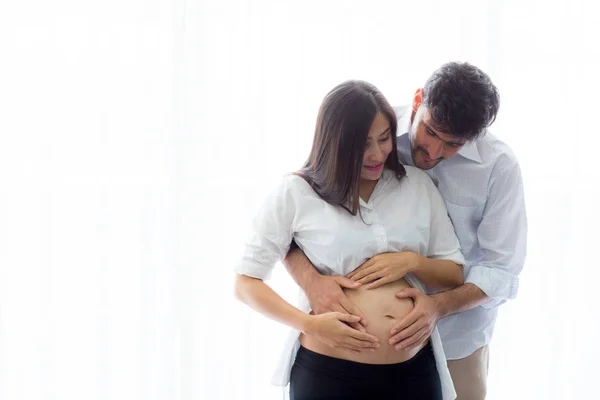 Embarazada madre y padre de pie abrazo celebración vientre, famil —  Fotos de Stock