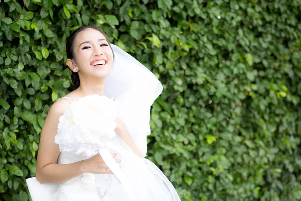 Bela jovem no dia do casamento em vestido branco na árvore — Fotografia de Stock