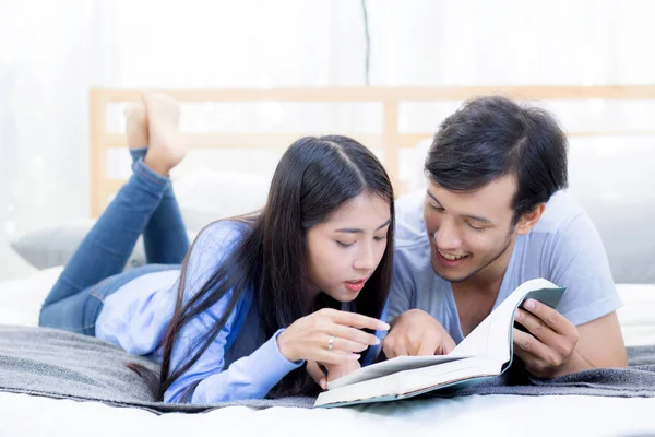 Casal lendo um livro juntos no quarto na manhã com ha — Fotografia de Stock