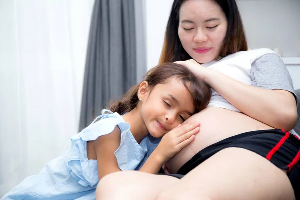 Pequeño niño escuchando al bebé en el vientre y abrazando a la madre con happine —  Fotos de Stock