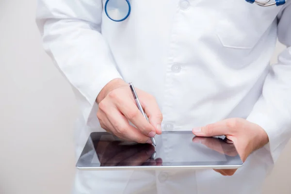 Médico trabalhando em um tablet digital em fundo branco . — Fotografia de Stock