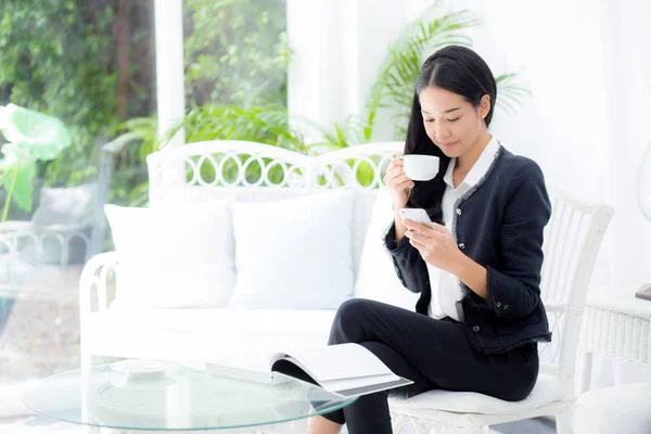Joven mujer de negocios asiática sentada en la mesa en la cafetería y lo —  Fotos de Stock