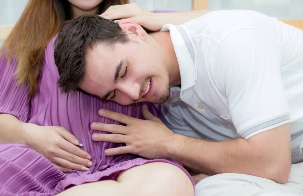 Beautiful pregnant asian woman and husband listening to baby wit — Stock Photo, Image