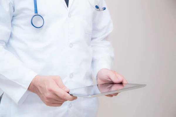 Médico trabalhando em um tablet digital em fundo branco . — Fotografia de Stock