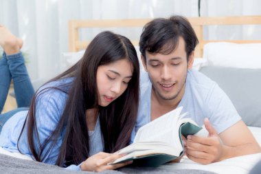 Çift ha ile sabah yatak odasında birlikte bir kitap okuma