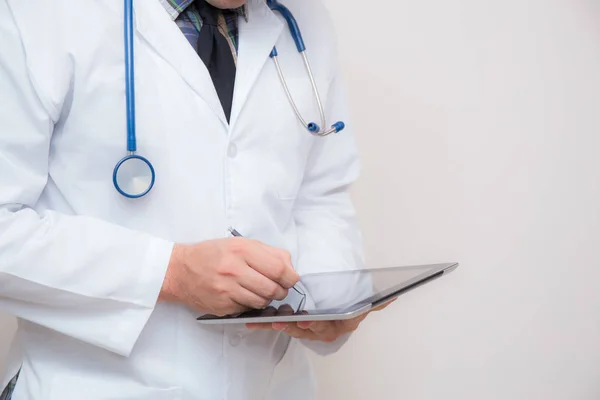 Médico trabalhando em um tablet digital em fundo branco . — Fotografia de Stock