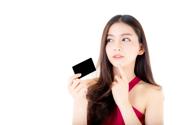 Asiática joven con vestido rojo sosteniendo una tarjeta de crédito pensando — Foto de Stock